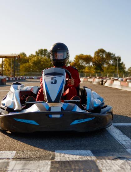 Persona in go-kart su pista all'aperto sotto il sole.