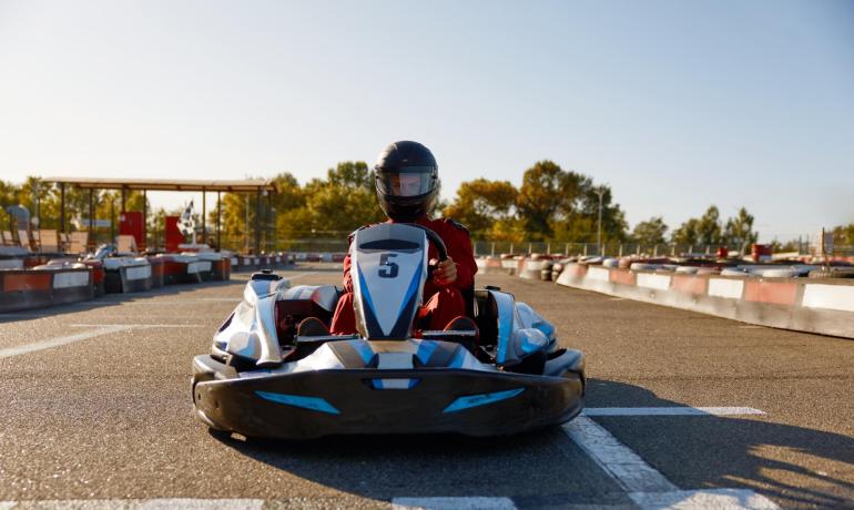 Persona in go-kart su pista all'aperto sotto il sole.