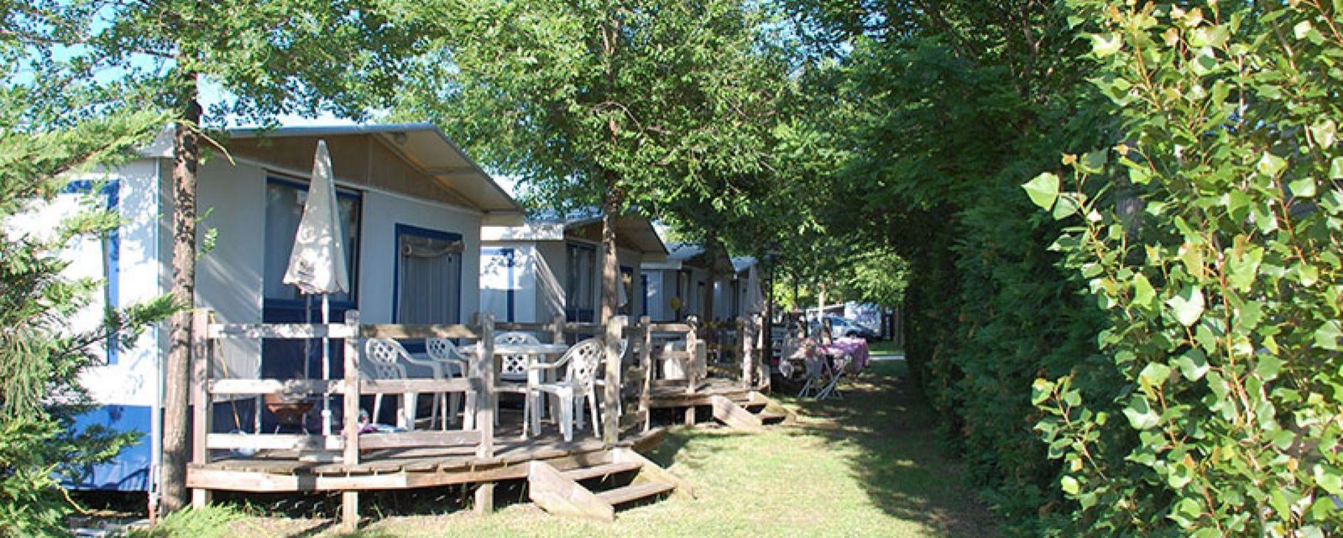 Bungalows in het groen met terrassen en buitenstoelen.