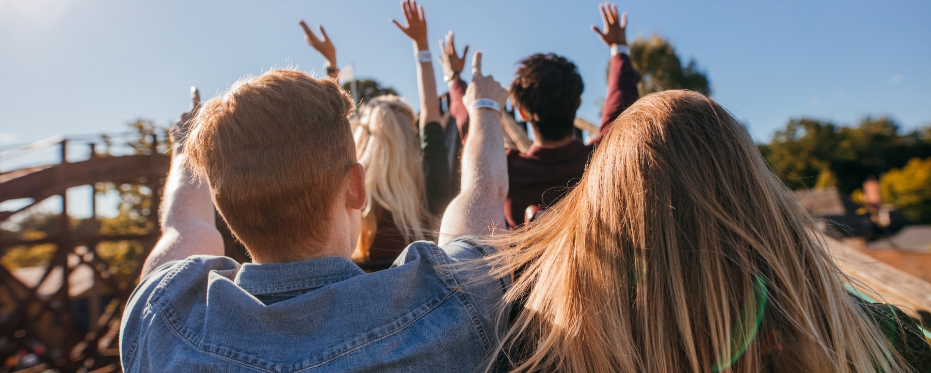 Gruppe von Menschen mit erhobenen Händen im Freien.