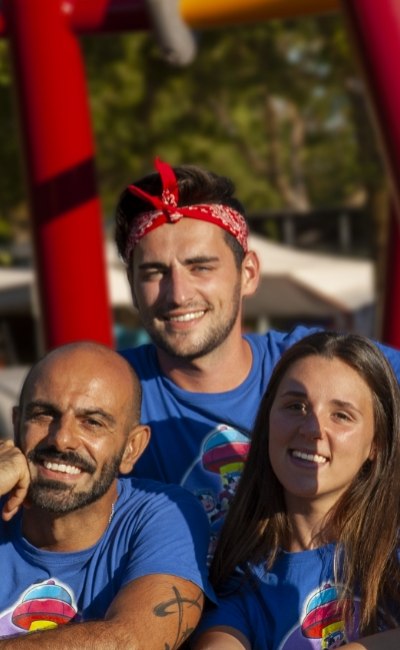 Groep lachende vrienden in blauwe shirts met kleurrijke achtergrond.