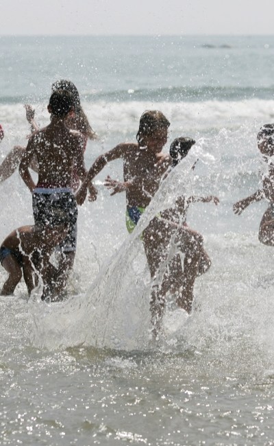 Kinderen spelen en spetteren op het strand.