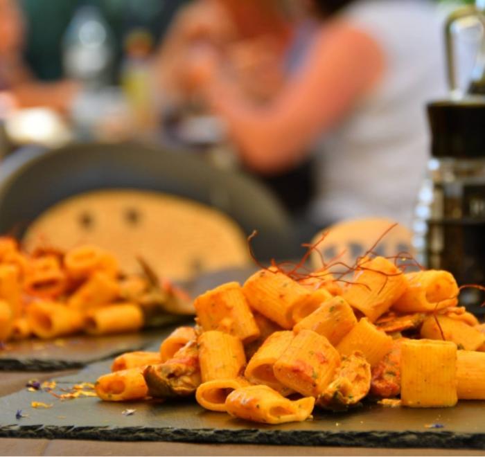 Pasta servita su piatto di ardesia in un ristorante all'aperto.