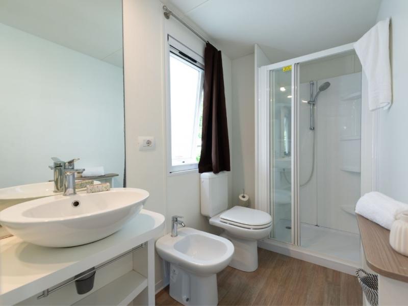 Moderne badkamer met douche, wastafel, bidet en toilet.